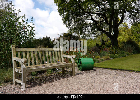 Un giardino in legno sedile in sole di primavera ad RHS ROSEMOOR. Foto Stock