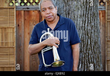 Musicista jazz in posa con il suo flicorno all'esterno. Foto Stock