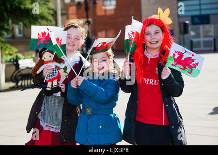 Tre bambini sventolando welsh drago rosso le bandiere e gli striscioni prendendo parte al giorno di San Davide parata e celebrazioni, Wrexham, 1 marzo 2015 Foto Stock