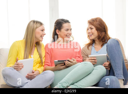 Tre sorridenti ragazze adolescenti con tablet pc a casa Foto Stock