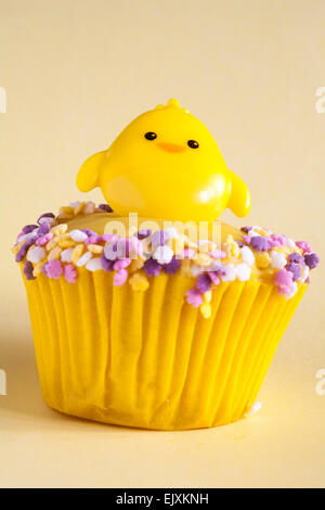 Pulcino di pasqua cupcake anello isolato sul pallido sfondo giallo Foto Stock