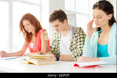 Stanco di studenti con i libri di testo e libri a scuola Foto Stock