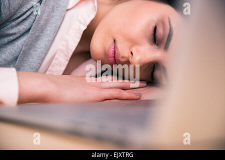 Bella donna d'affari di dormire sul tavolo in ufficio Foto Stock