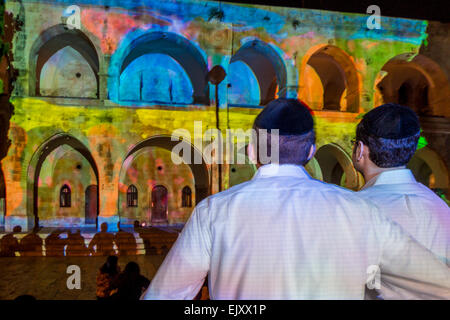 Gerusalemme, Israele. Due ebrei ortodossi uomini guardare uno spettacolo audiovisivo presso la vecchia città durante il 2013 la festa delle luci Foto Stock