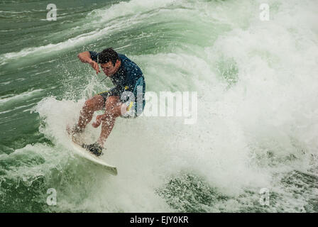 California surfer triturazione di un'onda vicino al molo a Manhattan Beach in California nella contea di Los Angeles. Stati Uniti d'America. Foto Stock