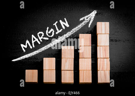 Parola di margine sulla freccia ascendente al di sopra del grafico a barre di legno di cubetti isolati su sfondo nero. Chalk disegno sulla lavagna. Il concetto di business dell'immagine. Foto Stock