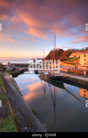 Sunrise riflessa nello storico porto di Charlestown vicino a St Austell sulla costa meridionale della Cornovaglia. Foto Stock