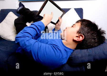 Bambino utilizza un iPad per comunicare e giocare. Foto Stock