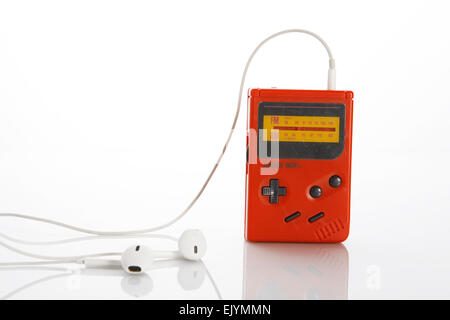 E il vecchio, vintage, rosso gameboy radio con cuffie bianche su sfondo bianco Foto Stock