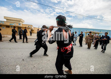 I musulmani sciiti flagellano loro stessi durante la processione di strada in un giorno di Ashura, decimo giorno di Muharram e commemorazione di Husayn ibn ali della morte, Mazar-i Sharif, Afghanistan Foto Stock