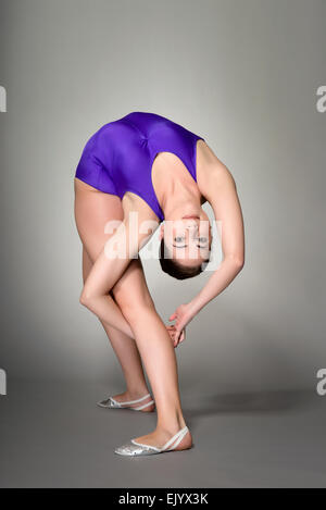 Giovani femmine contortionist, su sfondo scuro Foto Stock