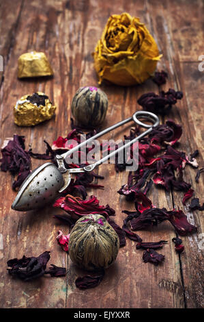 Infuso di tè varietà di hibiscus sullo sfondo crema pasticcera cucchiaio.L'immagine dai toni.Il fuoco selettivo Foto Stock