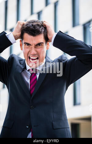 Angry business man strappando i capelli nella disperazione Foto Stock