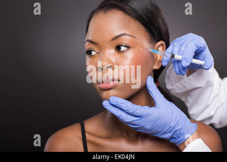 Bella Afro American donna ricevere un intervento di chirurgia plastica di iniezione sul suo viso Foto Stock