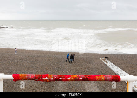 Aberystwyth, Wales, Regno Unito. 3 Aprile,2015. Guerriglia della maglia nella parte anteriore della Walkers spazzate dal vento sulla spiaggia.UK Meteo, cieli grigi non è in grado di sconfiggere la bellezza del Galles durante la Pasqua. Credito: Dave Stevenson/Alamy Live News Foto Stock