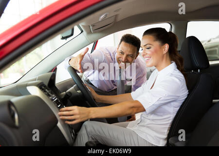 Auto Gentile consulente di vendita che mostra una nuova vettura per la giovane donna Foto Stock