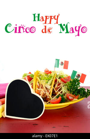 Happy Cinco de Mayo luminoso parte colorata del cibo con piatto di tacos rosso sulla tavola di legno. Foto Stock