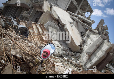 (150403) -- KOBANE (Siria), 3 aprile 2015 (Xinhua) -- un curdo guarda siriano a edifici distrutti al momento del suo arrivo in Kobane, Siria, 3 aprile 2015. Alcuni rifugiati siriani che erano fuggiti in Turchia tornò a Kobane dopo combattenti curdi sloggiato Stato islamico (SI) militanti dalla città. (Xinhua/Ahmad Halabisaz) Foto Stock