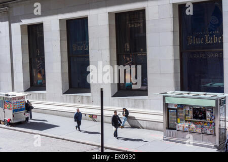 I pedoni a piedi giù Wall Street a New York, evocativo di Paul Strand's 1915 fotografia 'Wall Street', visto il Mercoledì, 1 aprile 2015. Strand non disponeva di un edicola o un frutto shake carrello al momento. (© Richard B. Levine) Foto Stock