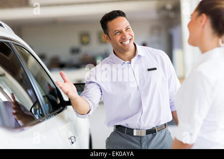 Gentile Venditore Vendita auto a un cliente in showroom Foto Stock