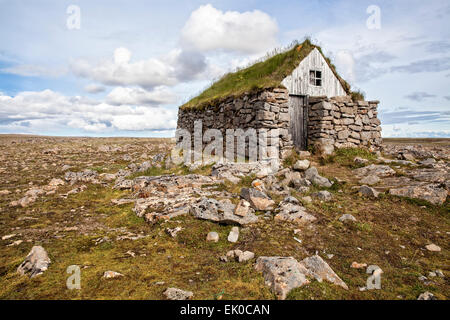 Vista di un tappeto erboso di pietra con tetto di casa rifugio nel Westfjords dell Islanda. Foto Stock