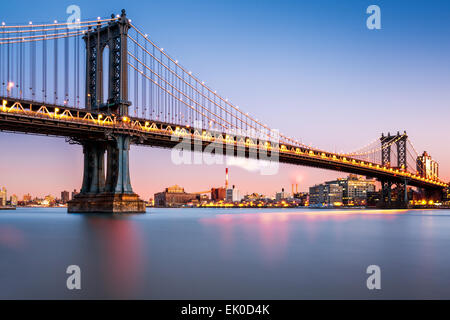 Manhattan Bridge illuminato al crepuscolo (molto lunga esposizione per una superficie perfettamente liscia acqua) Foto Stock