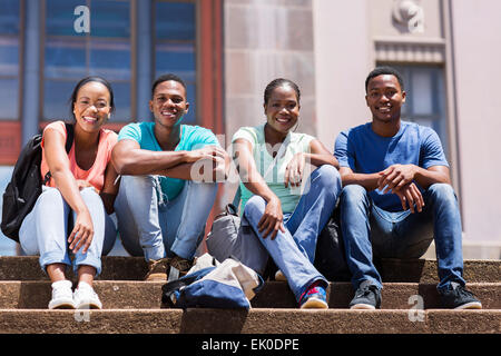 Gruppo di felice studente africano seduta al di fuori del college building Foto Stock