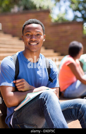 Buona ricerca africano maschio studente di college seduti sui gradini Foto Stock