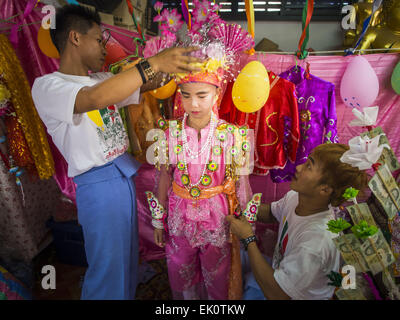 Chiang Mai, Thailandia. 4 apr, 2015. Gli uomini di aiutare un ragazzo entra nel suo abito cerimoniale per poi cantato lungo Festival presso il Wat Pa Pao in Chiang Mai. Poi ha cantato lungo Festival (chiamato anche i filati di poliesteri orientati hanno cantato lungo) è una cerimonia per Tai (anche e comunemente chiamato Shan, sebbene essi preferiscono Tai) ragazzi in stato Shan del Myanmar (Birmania) e in Shan europee nella parte occidentale della Thailandia. La maggior parte dei ragazzi di Tai andare nel monastero di monaci novizio a qualche punto di età compresa tra i sette e i quattordici. Credito: ZUMA Press, Inc./Alamy Live News Foto Stock