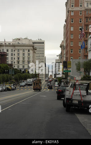 Cielo grigio ritratto, per il Bay Bridge, automobili parcheggiate e funivia sul pendio passato boutique hotels, Hotel California Street di San Francisco Foto Stock