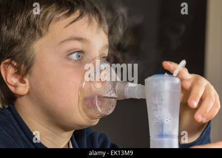 Bambino prendendo le vie respiratorie, la terapia di inalazione Foto Stock