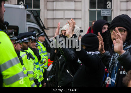 Whitehall, Londra, 4 aprile 2015. Come PEGIDA REGNO UNITO detiene un poco frequentati rally su Whitehall, punteggi di polizia sono chiamati a contenere contro manifestanti da varie Londra antifascista di movimenti. Nella foto: Anti-fascista contro manifestanti sollevare le mani a significare che essi non vogliono la violenza tra loro e la polizia che li separa dal PEGIDA rally. Credito: Paolo Davey/Alamy Live News Foto Stock