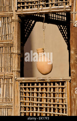 In ceramica boccale acqua appesa nella finestra di legno tralicciati shelter, Nizwa Fort, Nizwa, Oman Foto Stock