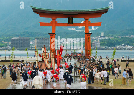 I sacerdoti a Torii Gate del santuario di Itsukushima durante Kangen-sai Festival, Miyajima, Giappone Foto Stock