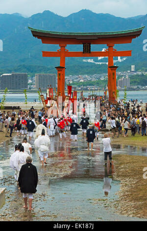 I sacerdoti a Torii Gate del santuario di Itsukushima durante Kangen-sai Festival, Miyajima, Giappone Foto Stock