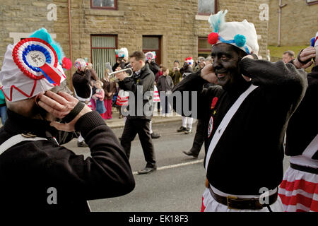 Bacup, Lancashire, Inghilterra, Regno Unito, 4 aprile 2015. Il Britannia Coco-dado ballerini danza il loro modo attraverso le strade di Bacup, Foto Stock