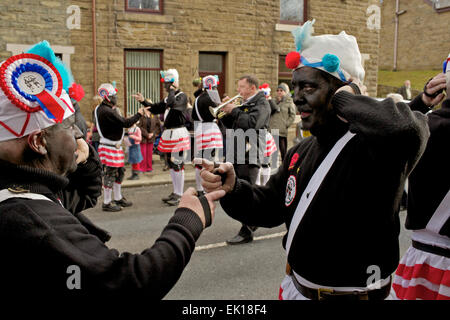 Bacup, Lancashire, Inghilterra, Regno Unito, 4 aprile 2015. Il Britannia Coco-dado ballerini danza il loro modo attraverso le strade di Bacup, Foto Stock