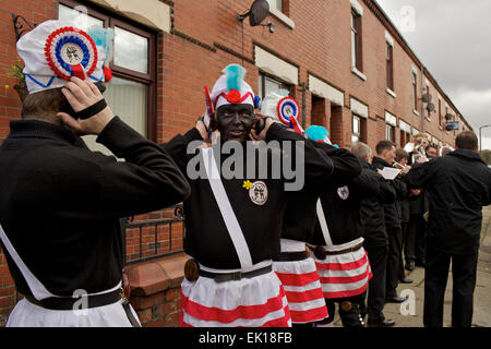 Bacup, Lancashire, Inghilterra, Regno Unito, 4 aprile 2015. Il Britannia Coco-dado ballerini danza il loro modo attraverso le strade di Bacup, Foto Stock