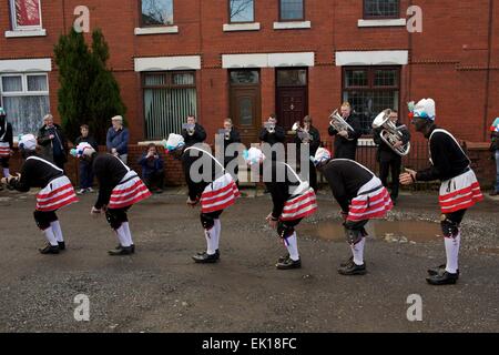 Bacup, Lancashire, Inghilterra, Regno Unito, 4 aprile 2015. Il Britannia Coco-dado ballerini danza il loro modo attraverso le strade di Bacup, Foto Stock