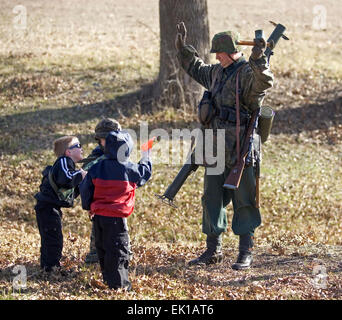 Ri-enactor nel Terzo Reich la II Guerra Mondiale SS uniforme di giocare con i bambini durante un weekend di raccolta in Ohio, Stati Uniti d'America. Foto Stock