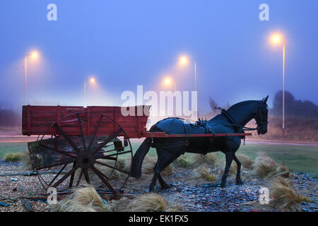 Replica di un carro di gamberi trainato da cavalli, o carrozza, originariamente utilizzata dai pescatori locali, situato sulla rotatoria di Weld Road, Southport. adiacente alla riva. Carri trainati da cavalli o veicoli meccanici utilizzati per reti da traino dietro di essi, un metodo di pesca noto come «shanking». Foto Stock