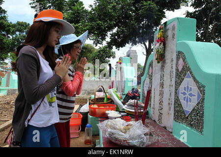 Palembang, Indonesia. 03 apr, 2015. Una famiglia cinese pregare durante Cheng Beng cerimonia. Cheng Beng, conosciuto in Cina come Qingming, è una tradizionale festa che segna l'inverno diventando la molla. Durante questo tempo, le famiglie di visitare le tombe dei loro antenati per pagare i loro aspetti, fare offerte e per pregare per una vita migliore © Muhammad Raden/Pacific Press/Alamy Live News Foto Stock