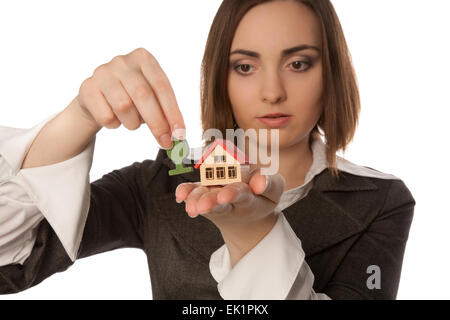 Immagine di una giovane donna di piantare un giocattolo albero vicino alla casa del giocattolo focus sulla casa) Foto Stock
