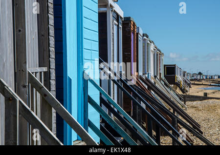 Fila di rifugi colorati sulla spiaggia a Thorpe Bay, Southend on Sea, Essex, Regno Unito. Capanne in legno inglesi. Soleggiato Foto Stock