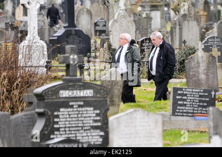 Belfast, Irlanda del Nord, Regno Unito. 5 Aprile, 2015. Due uomini vestiti di bianco e camicie, legami neri e nero si adatta a piedi attraverso un antico cimitero Credit: stephen Barnes/Alamy Live News Foto Stock