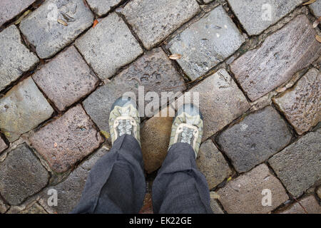 Piedi in scarponi in piedi su pietre ciottoli in giornata piovosa a Barcellona Foto Stock