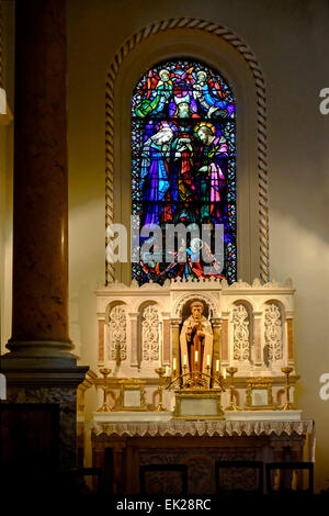 La chiesa carmelitana di Santa Teresa Dublino Irlanda, altare laterale che mostra finestra di vetro colorato e la statua di st. Francesco Foto Stock