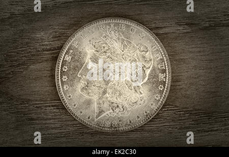 Vintage concetto di Silver Dollar in ottime condizioni su legno invecchiato. Lieve vignette bordo attorno alla moneta. Foto Stock