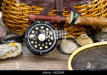 In prossimità di un antico wet fly fishing aspo, asta, landing net, mosche artificiali e le rocce di fronte cantra con legno rustico Foto Stock