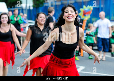 Ballerini di prendere parte a una street parade all'inizio di un festival Foto Stock